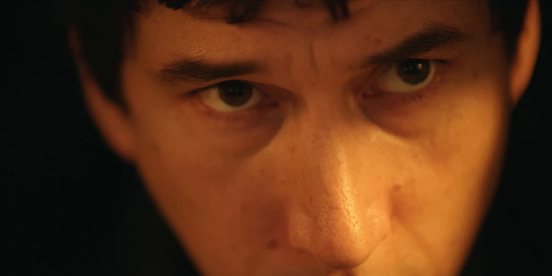 Extreme close-up of a man's eyes, warm light