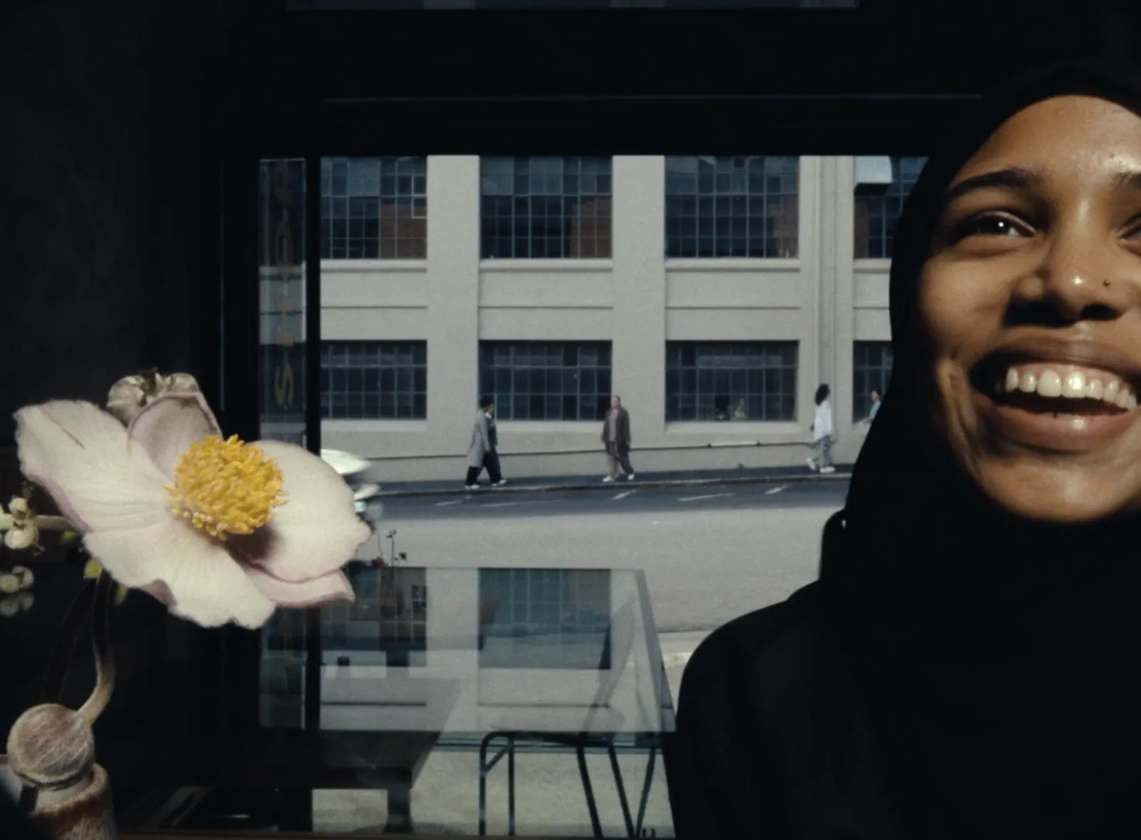 A woman laughing in a window-lit room